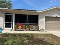 Charming single-story home with an attached garage and lovely flower boxes on the screened-in porch at 25801 Belle Helene, Leesburg, FL 34748