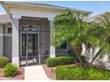 Inviting screened front porch with decorative plants, a seating area, and a clear view of the front door at 27027 Old English Ct, Leesburg, FL 34748