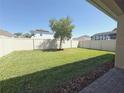 Spacious backyard featuring a well-maintained lawn, privacy fence, and ample space for outdoor activities at 2721 Picasso Ct, Kissimmee, FL 34743
