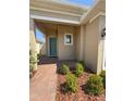 Inviting front porch with a bright blue door, neat landscaping, and a brick walkway at 2721 Picasso Ct, Kissimmee, FL 34743
