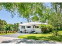 Cozy single-story home features well-maintained landscaping, a black driveway, and a welcoming entrance at 306 N Clayton St, Mount Dora, FL 32757