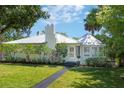 Charming one-story home featuring a metal roof, lush landscaping, and a well-manicured front lawn at 306 N Clayton St, Mount Dora, FL 32757