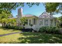 Charming home featuring a lush front yard, beautiful landscaping, and unique architectural details at 306 N Clayton St, Mount Dora, FL 32757