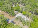 Aerial shot showcasing the home's roof, driveway and surrounding lush, green trees and landscape at 3075 Cr 431N, Lake Panasoffkee, FL 33538