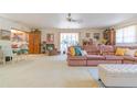 Spacious living room features neutral carpeting, a ceiling fan and natural light from large windows at 3075 Cr 431N, Lake Panasoffkee, FL 33538