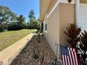 Close up of a home exterior with manicured landscaping and an American flag at 31728 Nutmeg Ave, Eustis, FL 32736