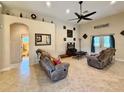 Bright living room with tile flooring, neutral walls, a ceiling fan, and comfortable reclining sofas at 31728 Nutmeg Ave, Eustis, FL 32736