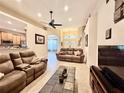 Open concept living area with tile floors, two sofas, and a view into the kitchen at 31728 Nutmeg Ave, Eustis, FL 32736