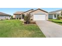Single-story home featuring an attached garage, tidy landscaping, and a well-kept lawn at 3396 Greenacres Ter, The Villages, FL 32163