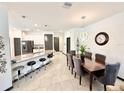 Bright, modern kitchen with stainless steel appliances, large island with seating, and stylish pendant lighting at 34004 Sky Blossom Cir, Leesburg, FL 34788