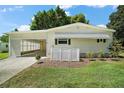 Inviting single-story home featuring a screened carport and lovely landscaping, enhancing curb appeal at 34407 Island Dr, Leesburg, FL 34788