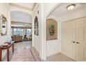 Welcoming foyer with tile accents, arched doorways, and view of the living room with a lake view at 3723 Belle Rose Dr, Leesburg, FL 34748