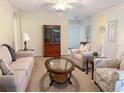 Cozy living room with plush seating, a ceiling fan, neutral walls, and a glass coffee table at 4387 Sambourne St, Clermont, FL 34711