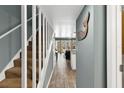 Hallway with wood-look tile floors, stairs, and view of the living area with balcony and water view at 4841 Saxon Dr # E206, New Smyrna Beach, FL 32169