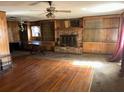 Spacious living room with hardwood floors, fireplace, ceiling fan, and built-in bookshelves at 504 S 12Th St, Leesburg, FL 34748