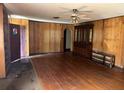 Bright living room with wood paneling, hardwood floors, and traditional built-in cabinet at 504 S 12Th St, Leesburg, FL 34748