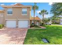 Lovely townhome featuring a two-car garage, terracotta tiled roof, and lush landscaping for a great curb appeal at 5340 Edgewater Way # 1, Oxford, FL 34484