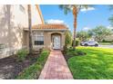Inviting front entrance with a brick walkway, lush landscaping, and a decorative glass door, creating a welcoming curb appeal at 5340 Edgewater Way # 1, Oxford, FL 34484