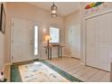 Bright foyer with tile flooring, a decorative rug, a coat closet, and a view of the front door and adjacent rooms at 631 San Pedro Dr, The Villages, FL 32159
