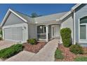 Inviting front porch featuring white railings, brick accents, lush landscaping, and a welcoming walkway to the front door at 631 San Pedro Dr, The Villages, FL 32159
