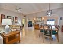Spacious living room featuring tile flooring, a ceiling fan, an adjacent dining area, and abundant natural light at 631 San Pedro Dr, The Villages, FL 32159