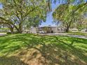 Beautiful single-story home with large, shady trees and a well-kept front lawn at 715 Megan Circle, The Villages, FL 32159