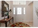 Bright foyer featuring stylish decor, including a decorative mirror, lamps, and a patterned rug at 760 Hammond Pl, The Villages, FL 32162