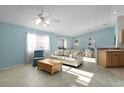 Bright living room with tile floors, fan, and light blue walls, seamlessly connecting to the dining area at 9325 Se 172Nd Garden St, The Villages, FL 32162