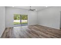 Bright living room with luxury vinyl plank flooring, recessed lighting, and sliding glass doors to the backyard at 16374 Se 88Th Ave, Summerfield, FL 34491