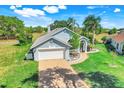 Charming single-story home with a brick driveway, two-car garage, and well-manicured lawn at 16538 Rockwell Heights Ln, Clermont, FL 34711