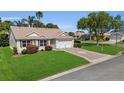 Charming home with beautiful lawn, landscaping and a decorative driveway at 1743 Landrum Ln, The Villages, FL 32162