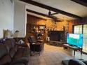 Inviting living room with stone fireplace, wood paneling, beamed ceilings, and ample natural light at 19726 Mccall Rd, Altoona, FL 32702
