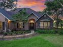 Attractive single Gathering home boasts manicured lawn, walkway, mature trees and stone accents at 2010 Otters Pond Rd, Fruitland Park, FL 34731