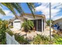 Charming home featuring a white garage door, flowering shrubs, and a screened-in lanai at 2095 Thornton Ter, The Villages, FL 32162