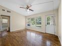 Inviting living room with a view of the backyard through large windows and a ceiling fan at 25519 Colmar Ave, Sorrento, FL 32776