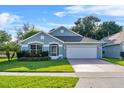 Inviting single-Gathering home with a lush green lawn, classic architecture, and an attached two car garage at 2749 Wilshire Rd, Clermont, FL 34714