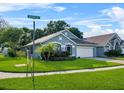 Attractive home situated on a corner lot, showcasing mature trees, an attached two-car garage, and a manicured lawn at 2749 Wilshire Rd, Clermont, FL 34714