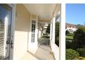 Inviting covered porch featuring white columns and railing, with views of the neighborhood at 292 Nautica Mile Dr, Clermont, FL 34711
