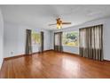 Bright living room featuring hardwood floors, large windows, and a ceiling fan, offering ample natural light at 2928 Delaney St, Orlando, FL 32806