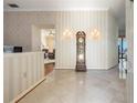 Elegant foyer with marble floors, decorative wallpaper, and a unique grandfather clock at 301 Waterwood Dr, Yalaha, FL 34797