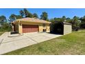 Large concrete driveway leading to a two-car garage and metal carport at 30554 Quince Ave, Eustis, FL 32736