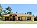Charming single-story home with tan stucco, red shutters, an arched entryway, and a well-manicured lawn at 30554 Quince Ave, Eustis, FL 32736