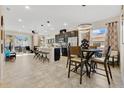 Open-concept layout with kitchen island, modern stainless appliances, adjacent dining area with stylish lighting at 31799 Broadwater Ave, Leesburg, FL 34748