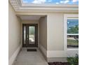 Inviting home entrance featuring a decorative glass front door and neutral stucco wall at 3305 Dzuro Dr, Oxford, FL 34484