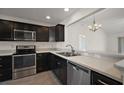 Modern kitchen with stainless steel appliances and dark cabinets, with view of eating area at 3305 Dzuro Dr, Oxford, FL 34484