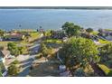 Aerial view showcasing a waterfront property with lush landscaping, mature trees, and access to the lake at 33801 Picciola Dr, Fruitland Park, FL 34731