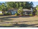 Charming single-story home featuring a well-maintained lawn and lush landscaping with mature trees and palms at 33801 Picciola Dr, Fruitland Park, FL 34731
