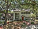 Charming two-story home with mature trees, shutters, brick walkway, and manicured landscaping at 3630 Oak St, Mount Dora, FL 32757