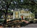 Stately two-story home with mature trees, shutters, brick walkway, and manicured landscaping at 3630 Oak St, Mount Dora, FL 32757