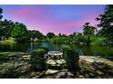 Scenic exterior view with a pond and table in a well-manicured backyard oasis at 3630 Oak St, Mount Dora, FL 32757
